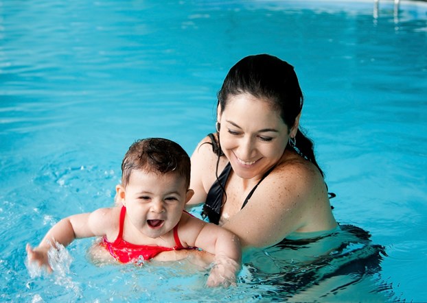 mamma/instruktör och bebis i bassäng